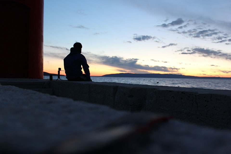 Silhouette einer Person beim Betrachten des Sonnenuntergangs am Meer