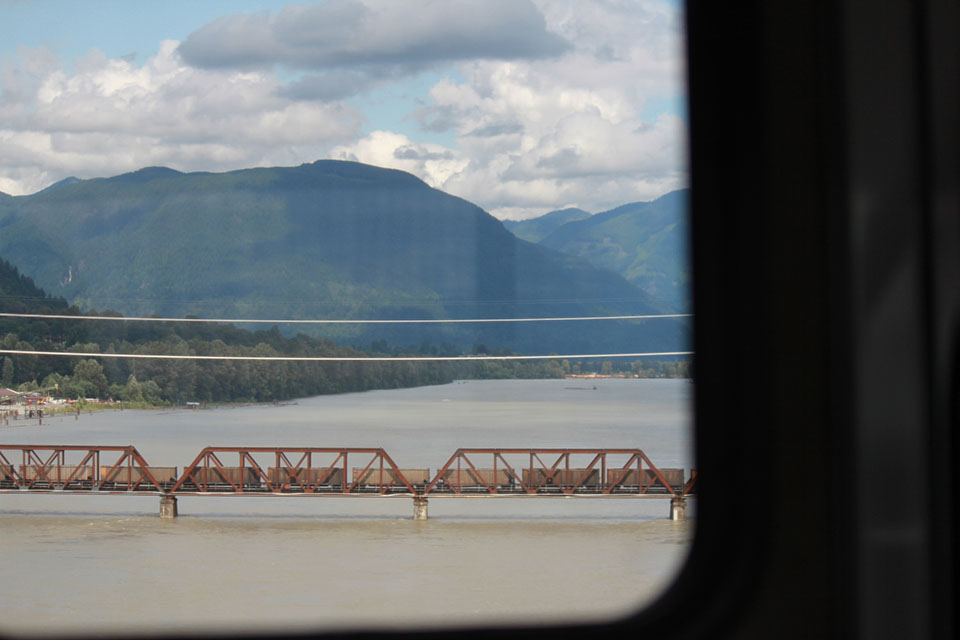 Güterzug auf einer Eisenbahnbrücke über den Fraser River, Blick aus dem Wohnmobilfenster