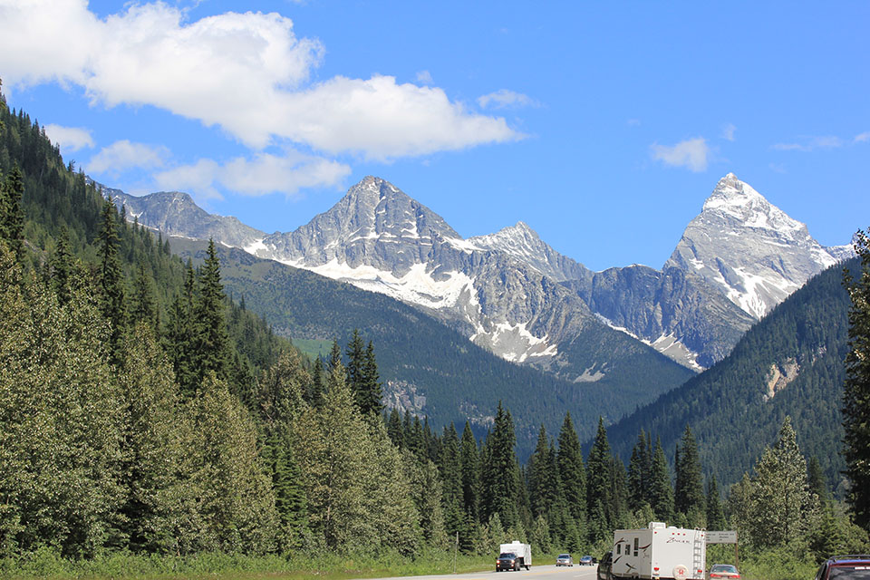 Schneebedeckte Gipfel der Rocky Mountains am Rogers Pass, Wohnmobile auf der Strasse