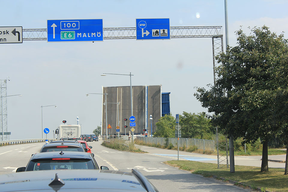 Verkehrsschild Richtung Malmö vor einer Klappbrücke, Blick durch die Frontscheibe des Campers