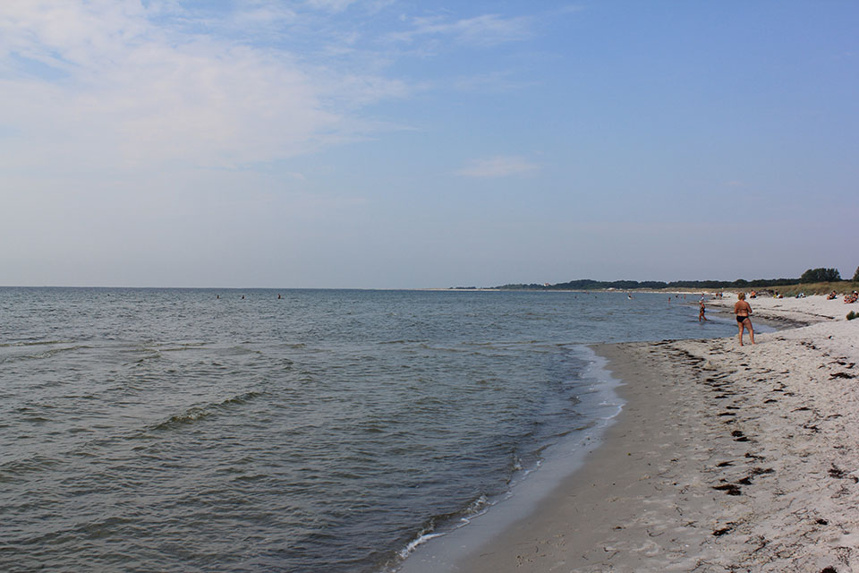 Sandstrand bei Falsterbo mit badenden Menschen an einem heissen Sommertag