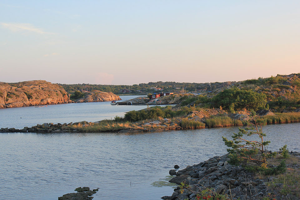 Schwedische Schärenküste im Abendlicht mit roten Holzhäusern am Wasser