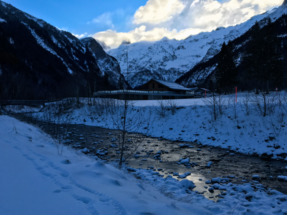 Bach im Schnee vor einem Chalet in der blauen Abendstimmung